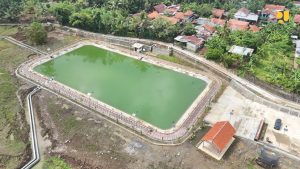 Penampakan fisik Embung Kedunggede di Banyumas yang dipenuhi air dengan latar belakang persawahan, serta fasilitas area terbuka yang asri.