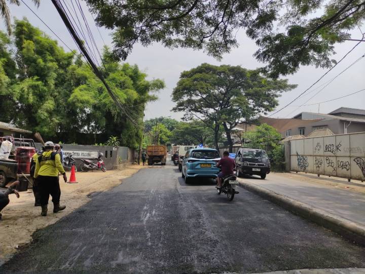 Petugas Dinas PUPR Kota Tangerang melakukan penambalan jalan menggunakan aspal panas di Jalan Pembangunan 3 Neglasari untuk memastikan keselamatan berkendara.