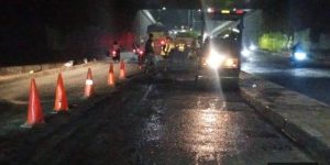 Petugas Dinas PUPR Kota Tangerang sedang melakukan pengaspalan ulang dengan material hotmix di Underpass Ciledug di bawah pencahayaan lampu jalan.