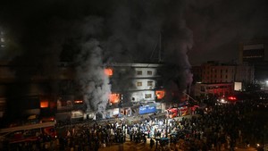 Foto udara bangunan asrama putri Utumishi Girls Academy di Nakuru yang hangus terbakar dengan atap seng yang runtuh, dikelilingi oleh garis polisi dan kerumunan petugas penyelamat.