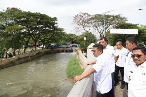 Deretan warung semi-permanen di pinggiran Situ Bulakan yang mulai dibongkar sendiri oleh pemiliknya di samping alat berat yang sedang mengeruk danau.