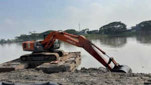 Alat berat ekskavator sedang mengeruk lumpur dan sedimentasi di Situ Bulakan Tangerang untuk memperluas daya tampung air.