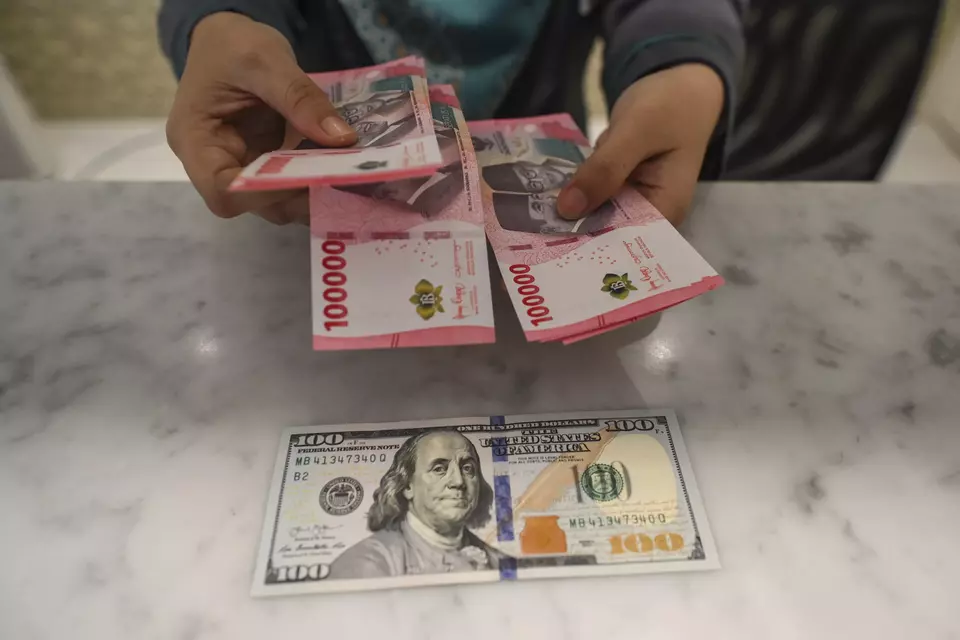 Grafik pergerakan nilai tukar mata uang rupiah terhadap dolar Amerika Serikat (AS) pada layar monitor perbankan yang menunjukkan tren penurunan ke zona merah, berlatar belakang ruang trading valuta asing.