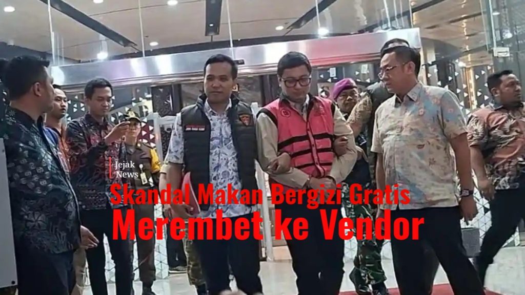 Tersangka Andri Mulyono mengenakan rompi tahanan merah muda Kejagung berjalan dengan tangan terborgol dikawal ketat petugas ke mobil tahanan.