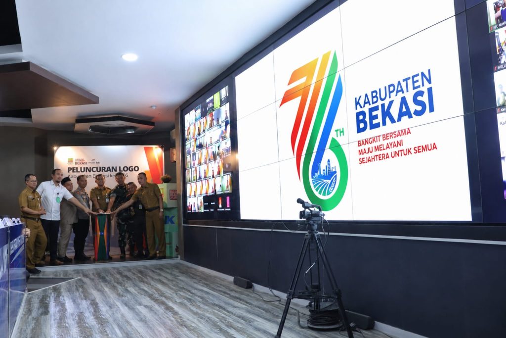 Tampilan grafis interaktif logo angka 76 bernuansa modern yang diproyeksikan pada layar digital utama ruang kendali darurat Pemerintah Kabupaten Bekasi.