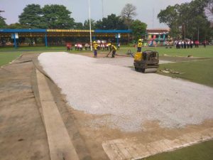 Petugas Dinas PUPR Kota Tangerang melakukan pengurukan dan perataan pasir fondasi di area rumput sintetis Lapangan Ahmad Yani.